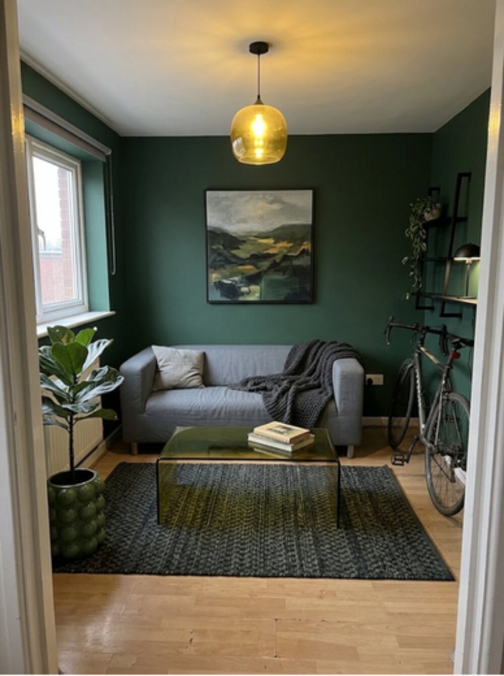 Green living room with framed art and rug — after transformation