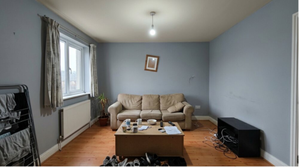 Grey-blue lounge with worn sofa — cluttered before